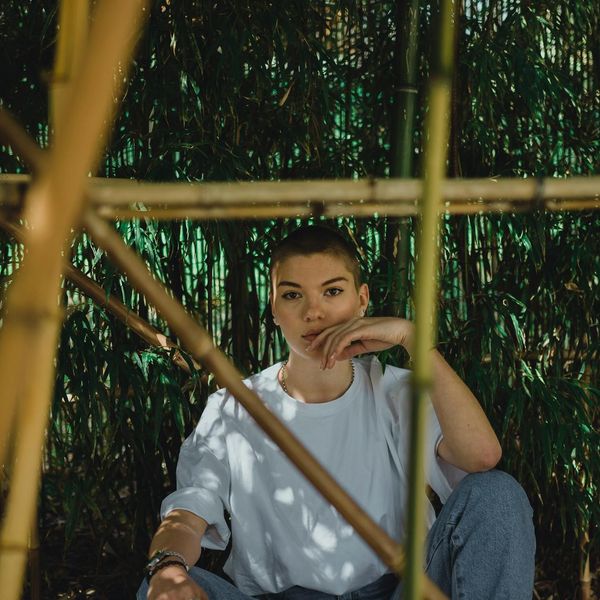 A person sitting in a meditative yoga pose with a serene expression.